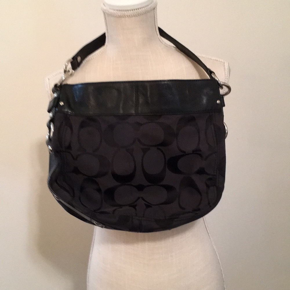 Black Coach purse with Coach lettering on the outside and light blue lining,